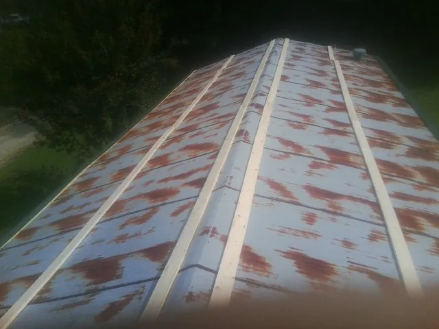 Rusted metal roof panels with new wood purlins before replacement — Storm Damage Roof Repair in Whitman by Roofing Brothers