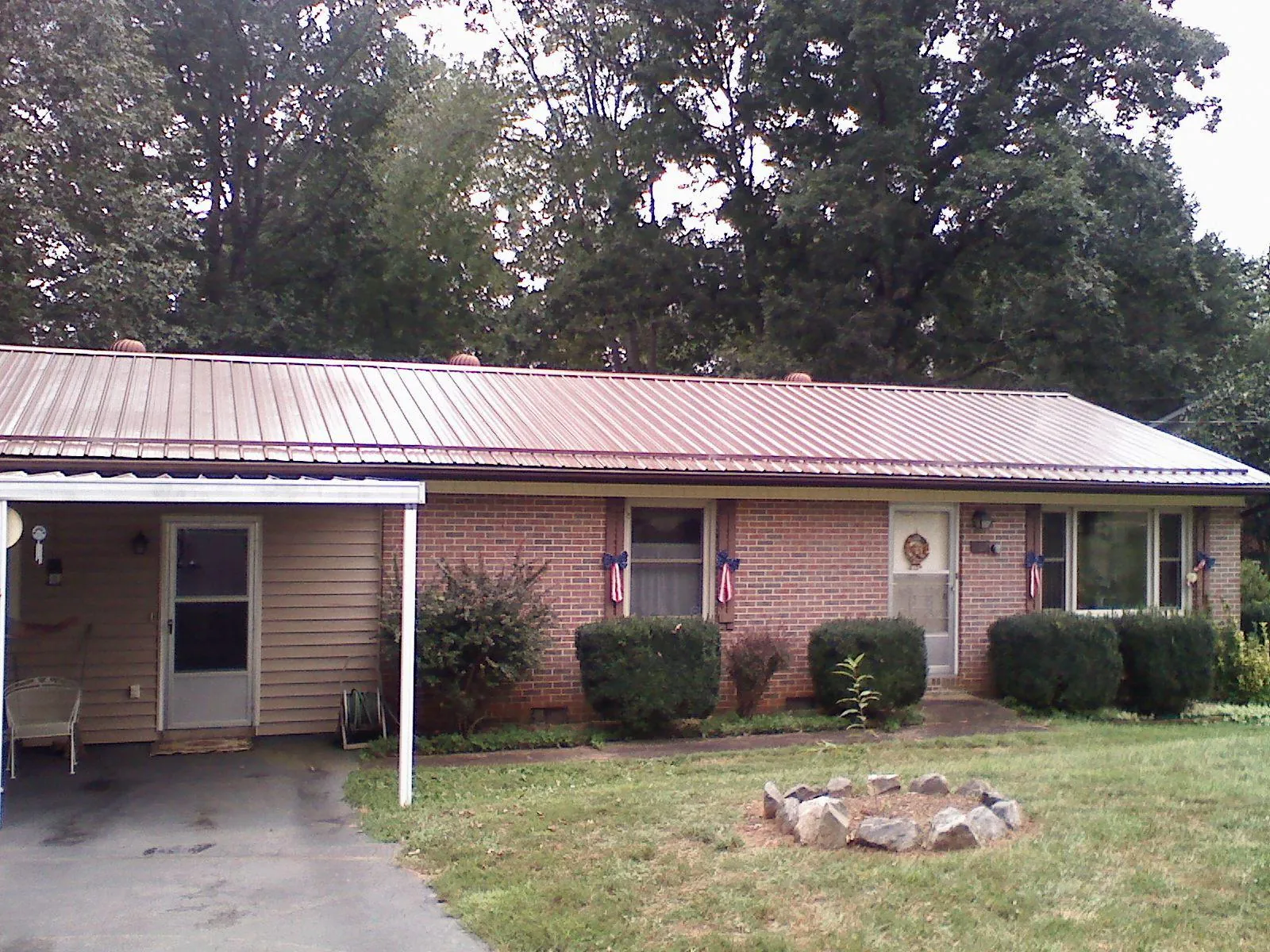 Bronze metal roof and carport on a brick ranch home — Roof Repair work by our crew in Whitman